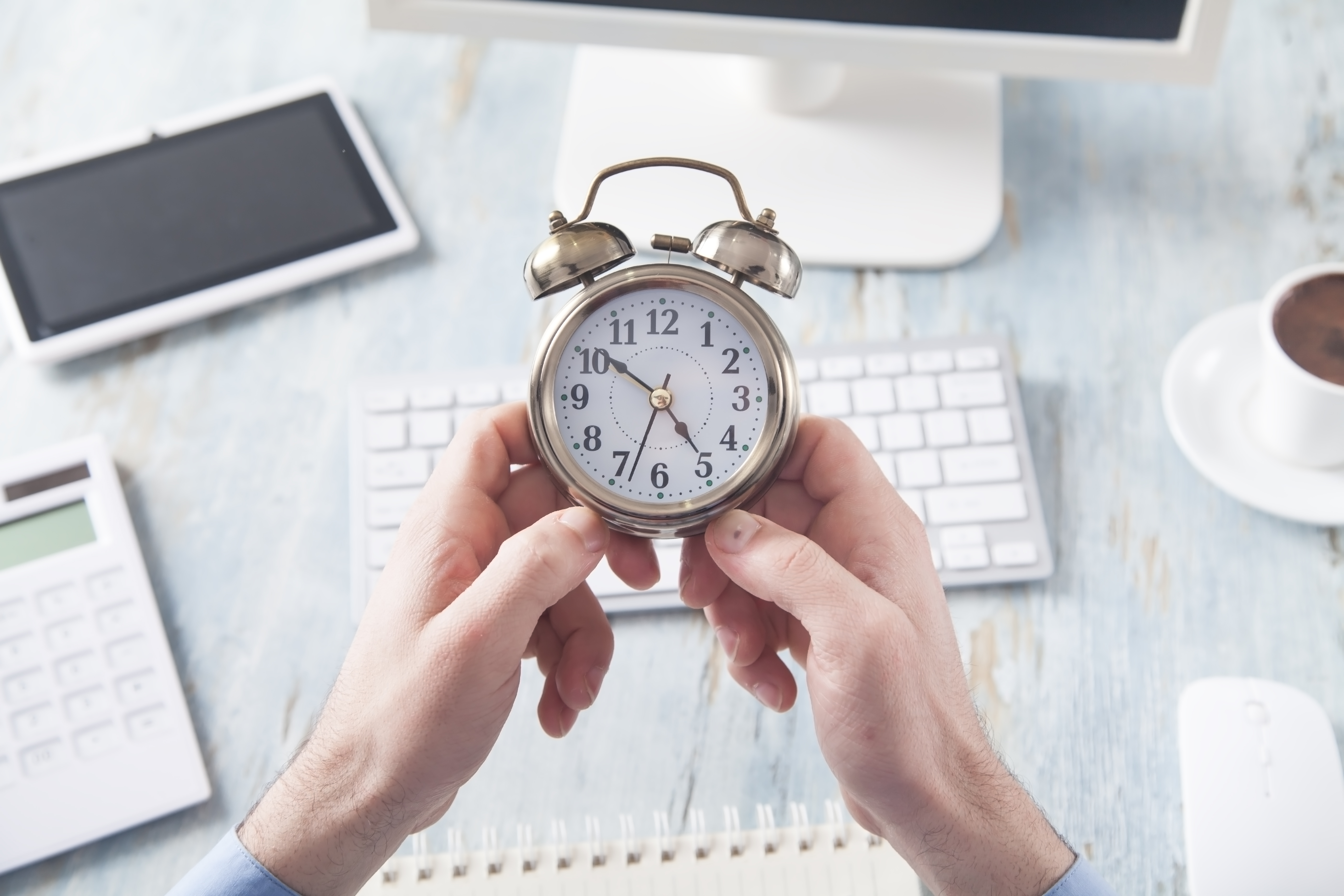 businessman-sitting-office-holding-alarm-clock-1