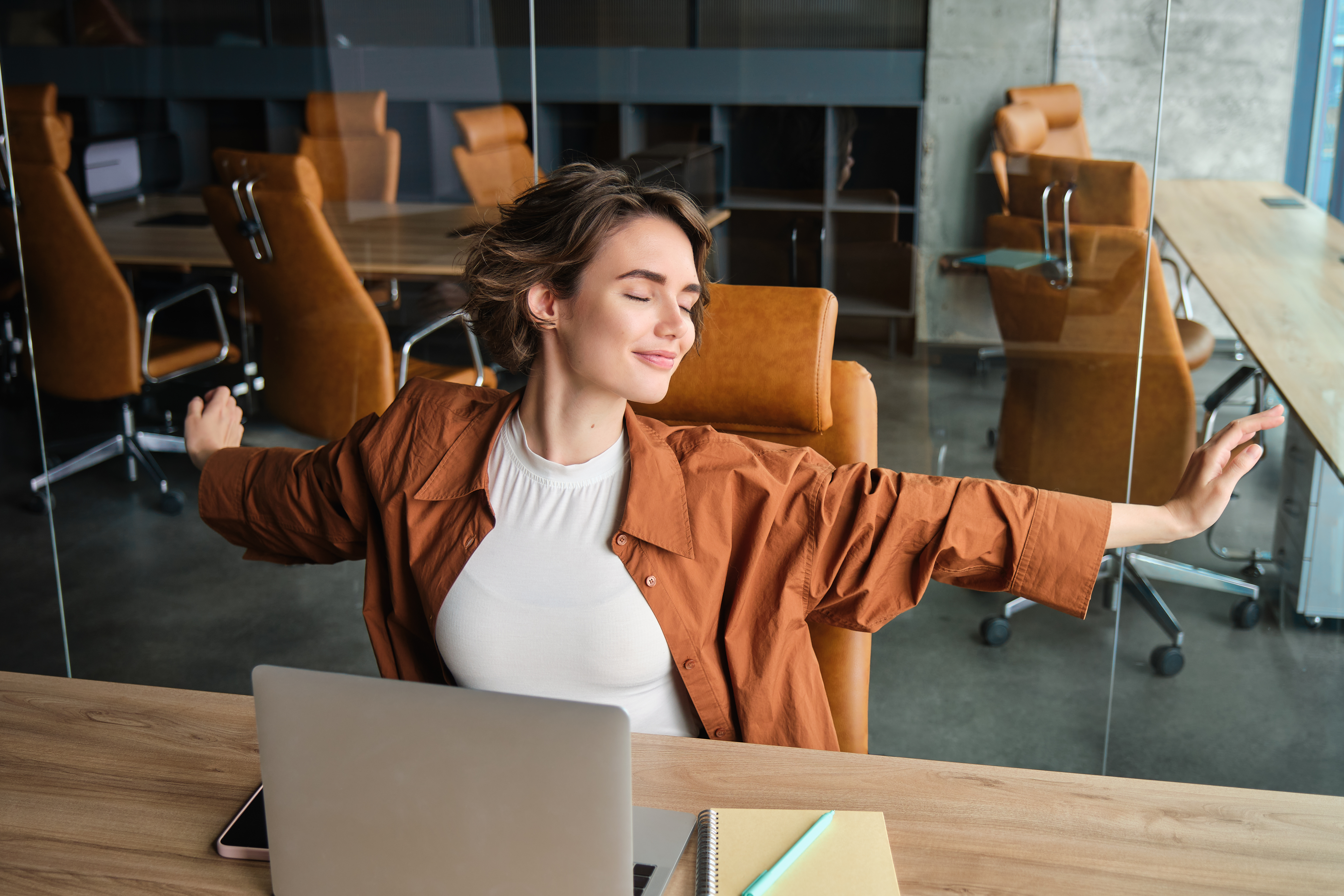 portrait-woman-resting-office-stretching-arms-after-sitting-working-laptop